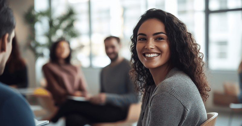 A woman smiling with her colleagues during a collaborative working session. 