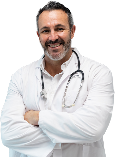 Confident physician stands smiling in a hospital hallway, representing frontline healthcare dedication
