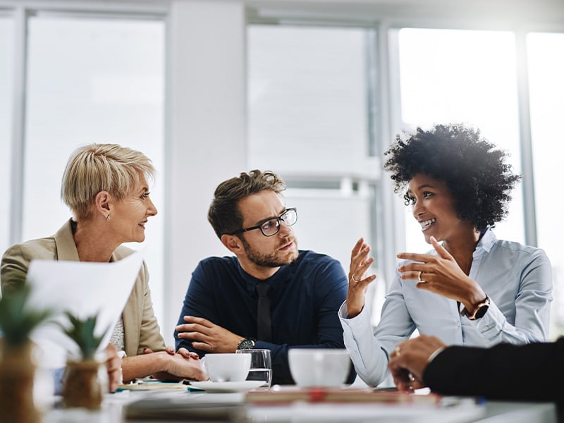 Diverse team engaged in a lively discussion around a conference table