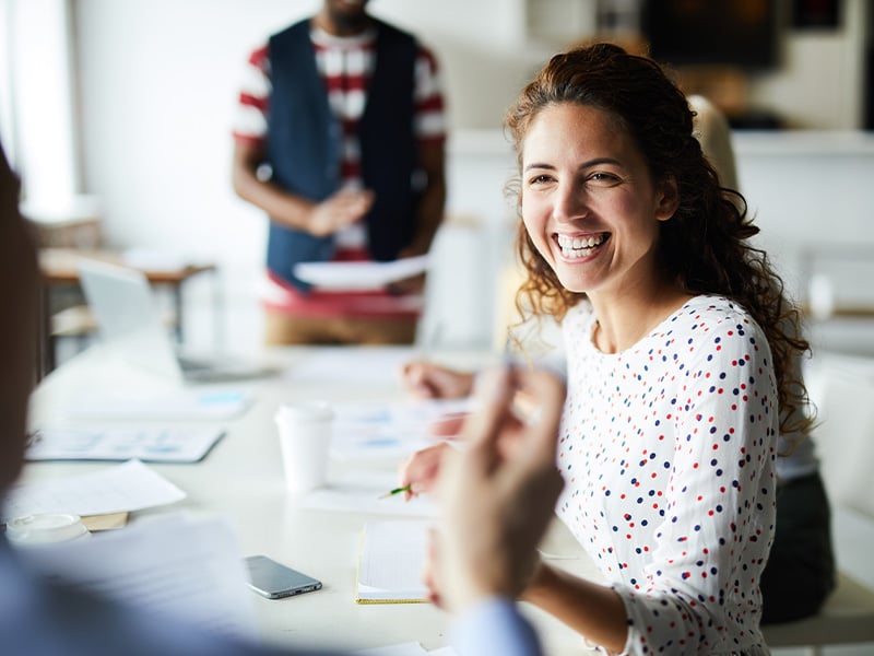 Employee beaming with joy during an upbeat team meeting at the office
