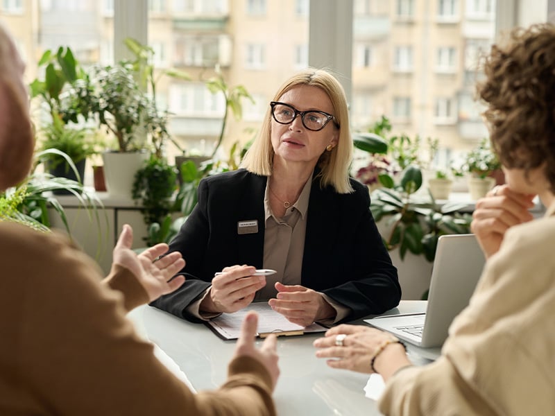 Employee attentively listening during a one-on-one meeting in a plant-filled office