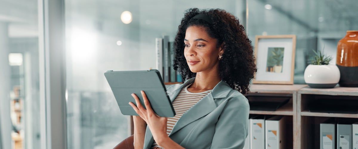 HR professional reviewing employee engagement data on a tablet in her office