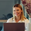 Smiling woman sales manager working on laptop in office environment