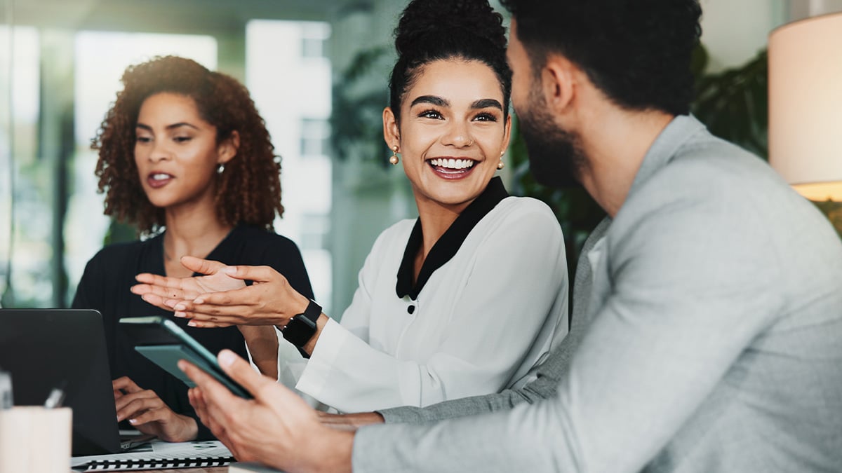 Team members laugh together during a lively, collaborative office discussion