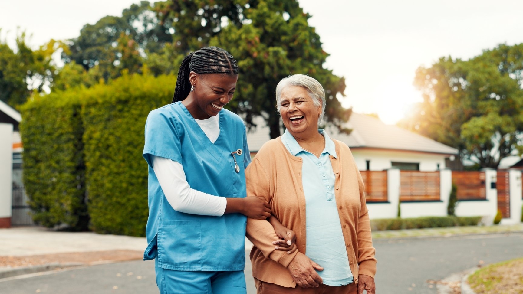 Senior, woman and walking with nurse outdoor laughing